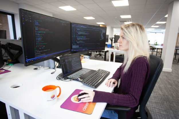 开发人员佩奇在她的办公桌上编程的图像